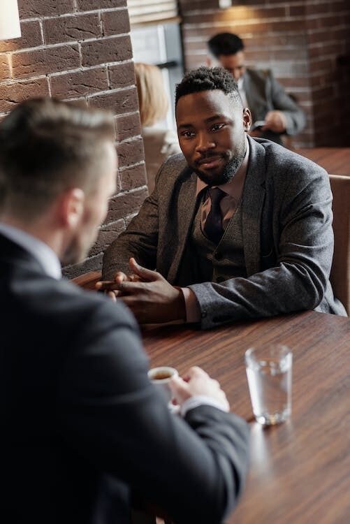 a private process server and a lawyer conversing during a meeting