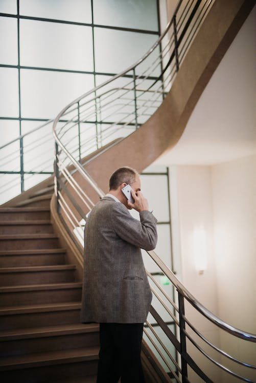 a process server talking on the phone on a staircase